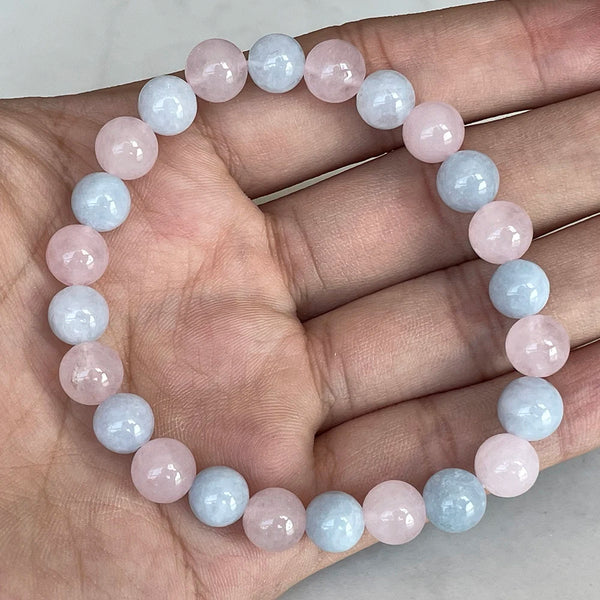Bracciale in perle di berillo e quarzo rosa nella mano di una persona