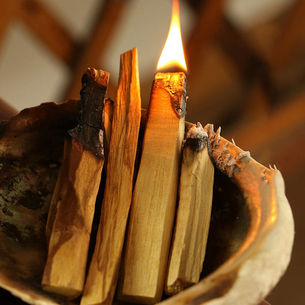 Set di dieci bastoncini di incenso in legno naturale che bruciano su una ciotola di legno